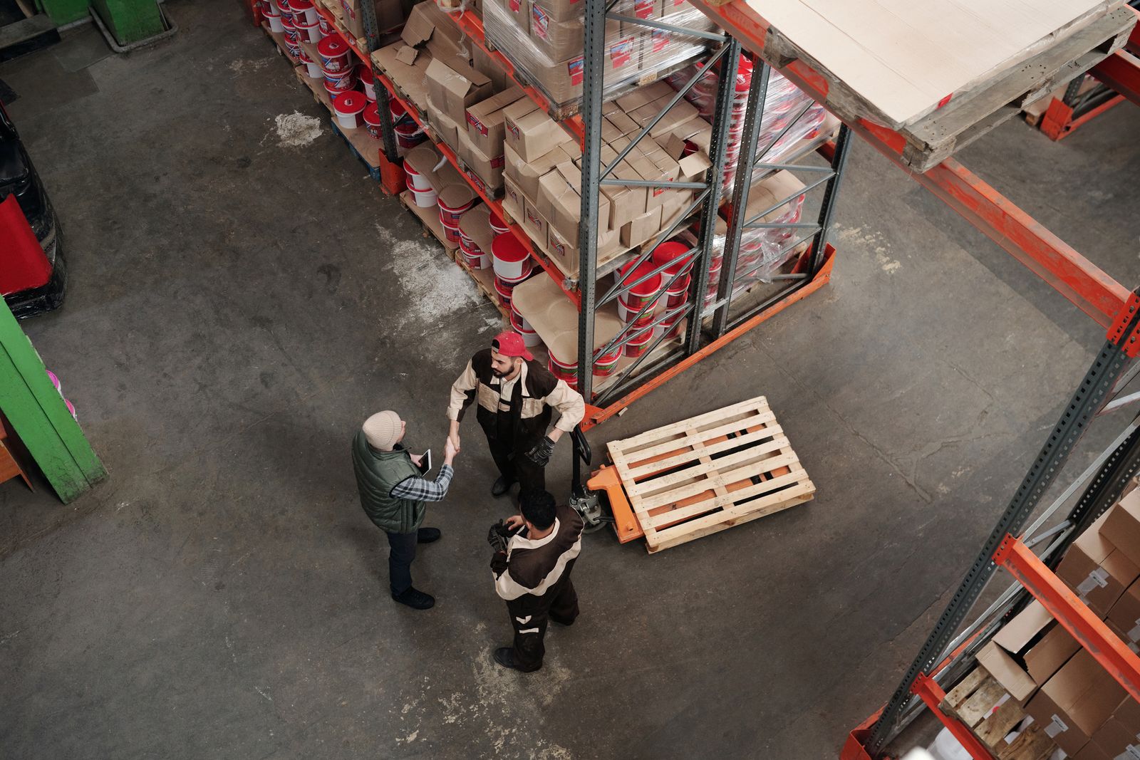 A small team talking together on the floor of a busy workplace.